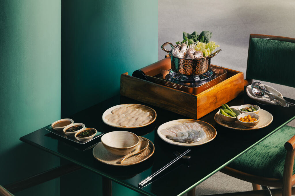 A table filled with food dishes at Siam Steamboat