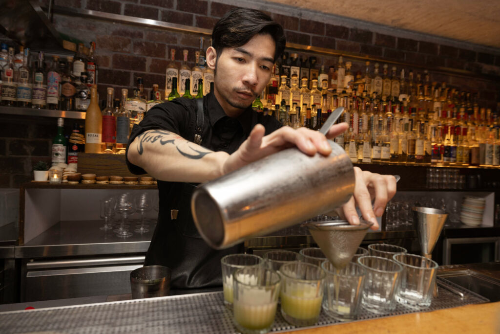 A bartender making a cocktail at COA