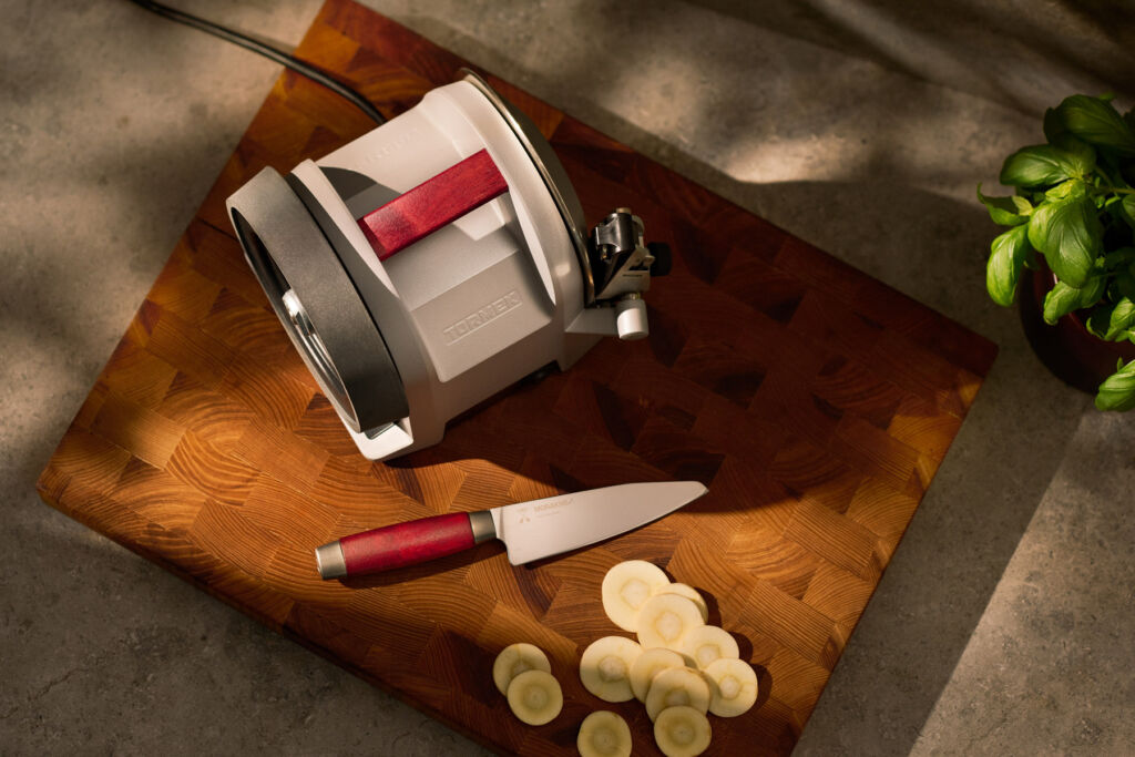 A top down view of the sharpener and knife on a wooden cutting block in the kitchen