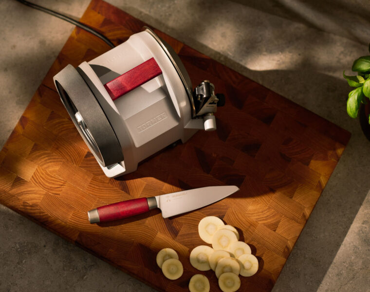 A top down view of the sharpener and knife on a wooden cutting block in the kitchen