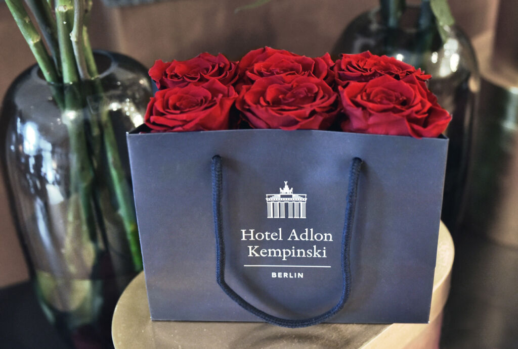 Six red roses inside the Adlon branded bag