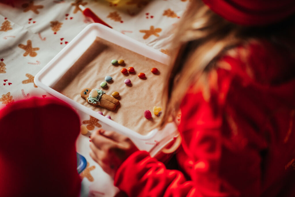 A young girl decorating a gingerbread man