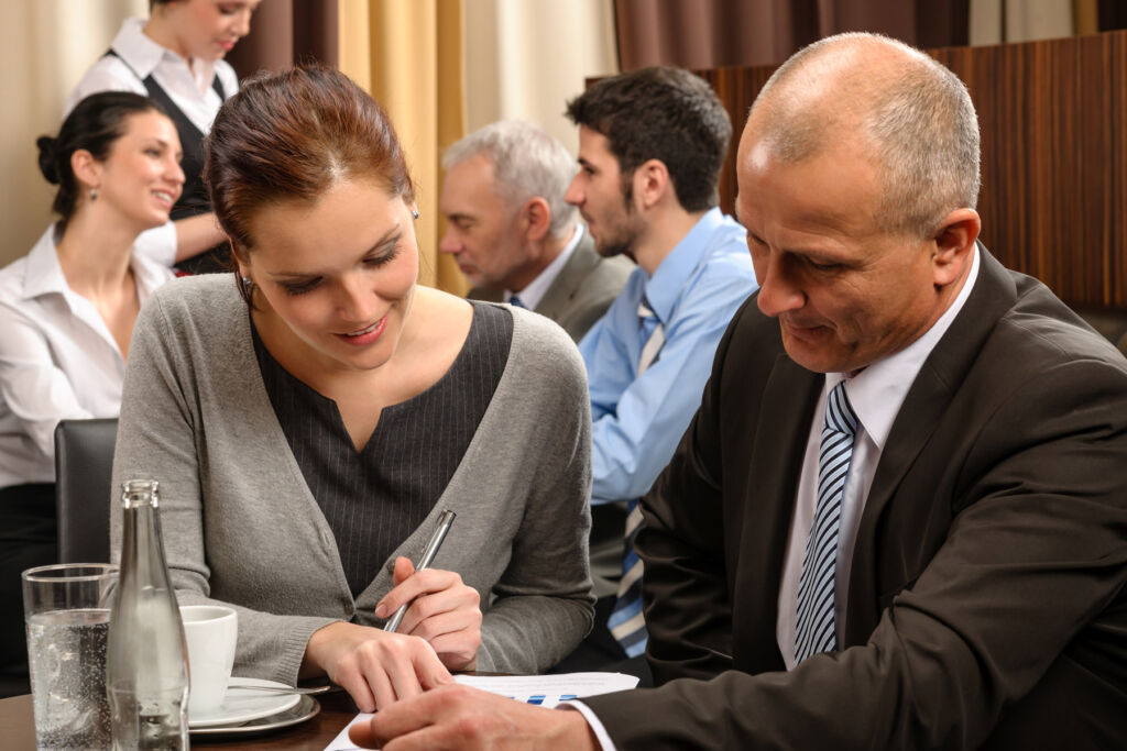 A young businesswoman talking to an older businessman