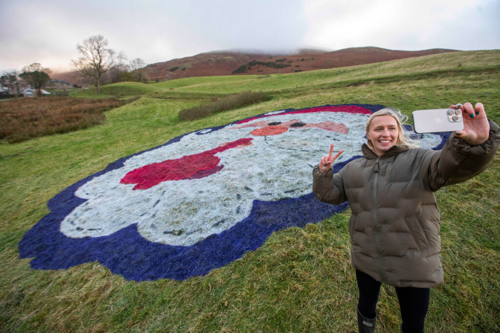 A woman standing in front of one of the giant faces