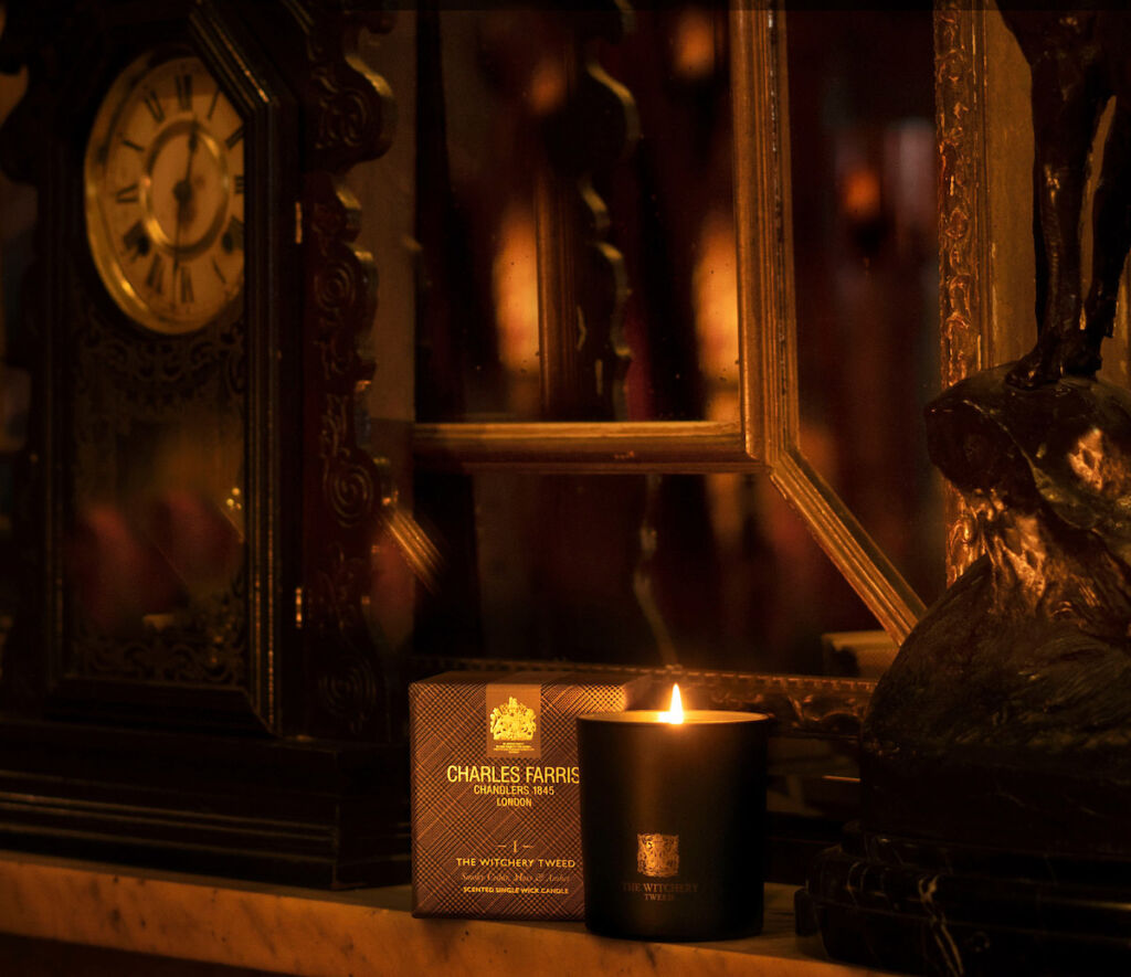 A lit luxury candle on a fireplace mantel