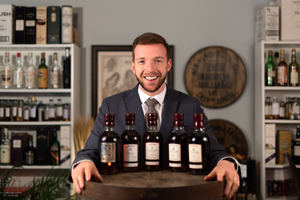 Mark Littler with five rare bottles placed on a barrel