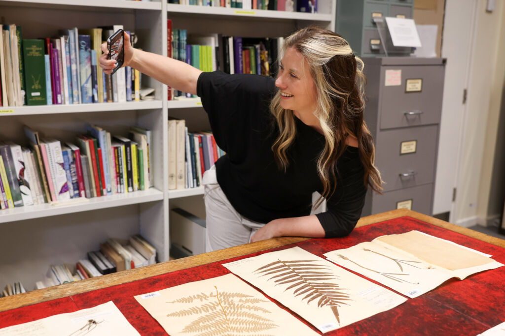 Phoebe taking a photograph of her with the work