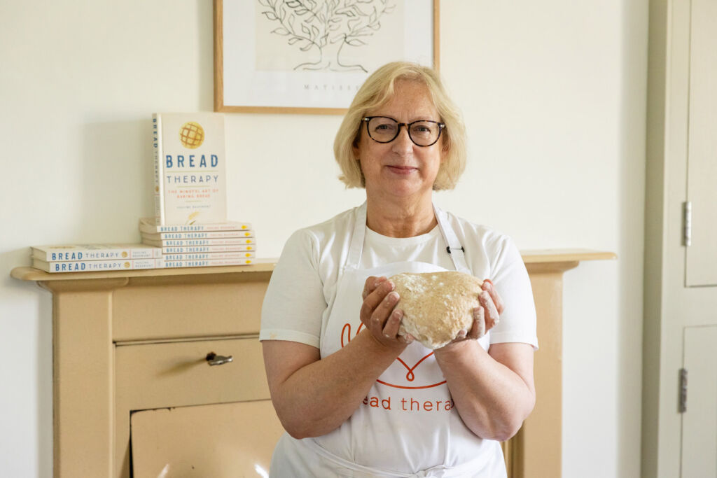 Pauling holding dough in her hands next to her inspirational book