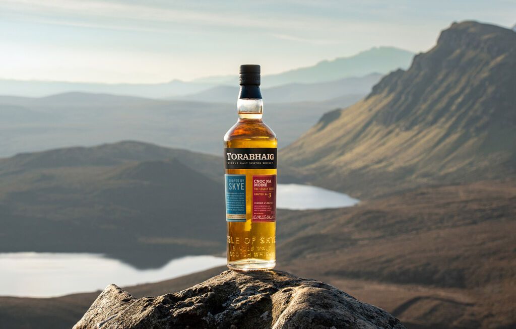 A bottle sitting atop a rocky peak overlooking the valleys