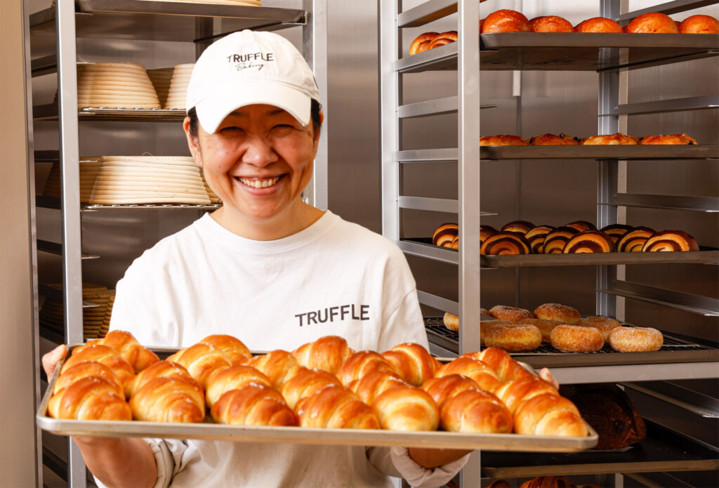 Chef Komata Naoko holding a tray of fresh baked breads