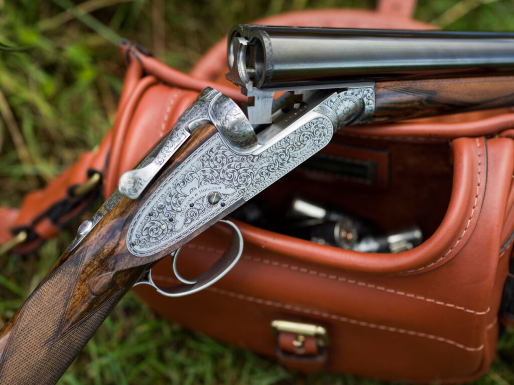 One of the handmade guns next to a leather branded holdall