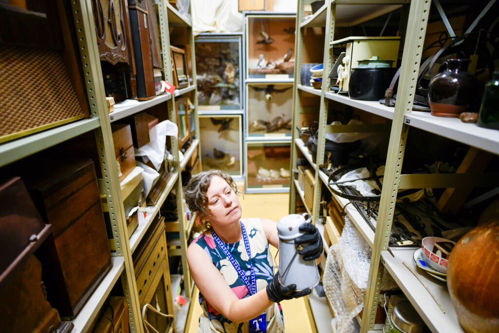 One of the museum curators examining an item in the storage area