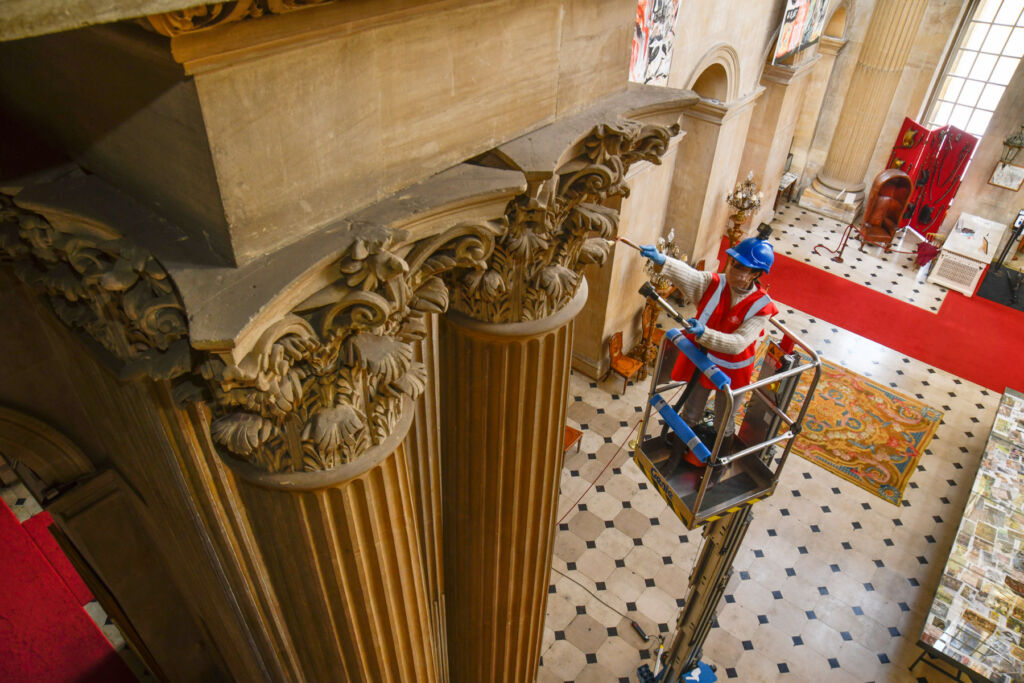 Columns getting cleaned via a team member on a hydraulic platform