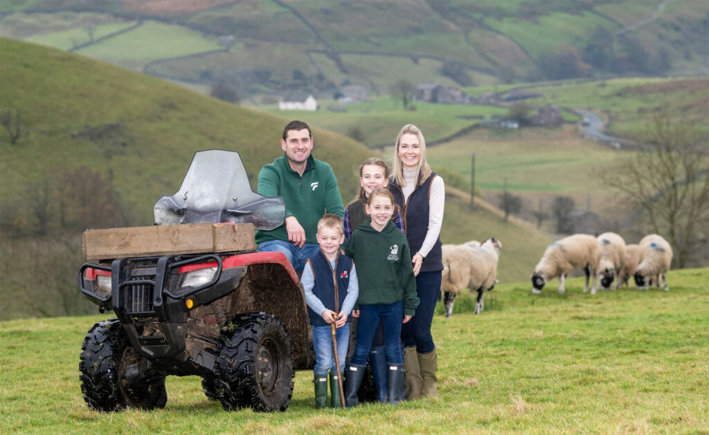 Linda with her family in a field with sheep