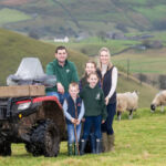 Linda with her family in a field with sheep