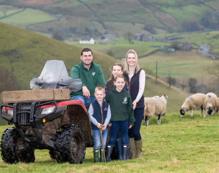 Linda with her family in a field with sheep