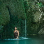 A woman relaxing under a waterfall