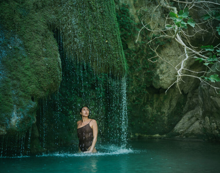 A woman relaxing under a waterfall